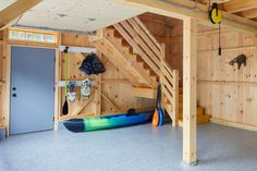 there is a kayak and paddles in the room with wooden walls on both sides