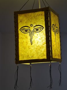 a lamp hanging from the ceiling with an eye on it's face and eyes drawn in black ink