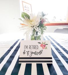 a vase filled with flowers sitting on top of a striped tablecloth covered table cloth