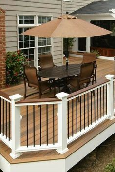 a deck with an umbrella and chairs on it