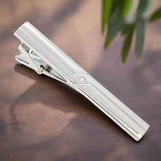 This chrome tie clip, adorned with intricate designs, adds a subtle yet sophisticated flair to any outfit. Its polished finish and detailed craftsmanship make it versatile and eye-catching. Dress Shirts: Solid Light Blue Dress Shirt - Provides a gentle contrast that highlights the intricate chrome details. White Dress Shirt with Fine Stripes - Adds a textured look while maintaining a classic style. Soft Pink Dress Shirt - Offers a stylish and modern touch that pairs well with the chrome finish. Soft Pink Dress, Charcoal Gray Suit, Light Blue Dress Shirt, Blue Dress Shirt, Light Blue Dress, White Dress Shirt, Silver Tie, Navy Suit, Blue Shirt Dress