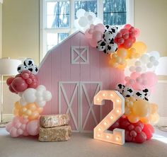 balloons are arranged around the number twenty two in front of a barn with a cow theme