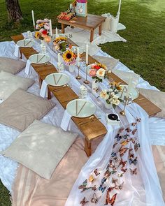 an outdoor table set up with sunflowers and plates