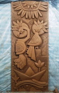 an intricately carved wooden panel with birds and flowers on it's face, in the shape of a sun