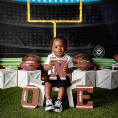 a little boy sitting on top of a chair holding up a sign that says football