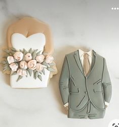 a cookie shaped like a suit and tie next to a fake flower arrangement on a marble surface