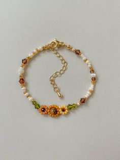 Bracelet Length: 6-8 inches  Each Bracelet has a 2 inch 14k gold filled extender This bracelet features different shades of hand woven yellow sunflowers and fall colors of cream, brown, green, and gold.  This dainty piece is made up of high quality seed beads including 24kt gold plated beads, crystals, and tigers eye. Strung on: Non-Stretchy Beading Thread How To Make A Sunflower Bracelet, Fall Beads Bracelet, Cheap Yellow Flower Bracelet, Small Bead Bracelets Ideas, Sunflower Beaded Bracelet, Daisy Chain Bracelet, Sunflower Bracelet, Yellow Bracelet, Armband Gold