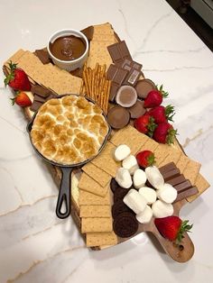 a platter filled with desserts and crackers on top of a marble counter