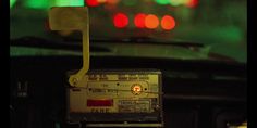 an old radio sitting on top of a table in front of a window with green and red lights behind it