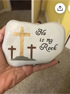 someone holding up a rock with a cross on it that says, he is my rock