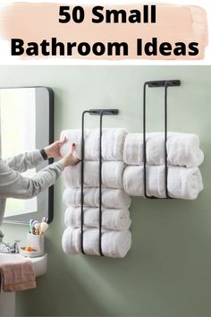 a woman is hanging towels on the wall in front of a mirror with text overlay that reads 50 small bathroom ideas