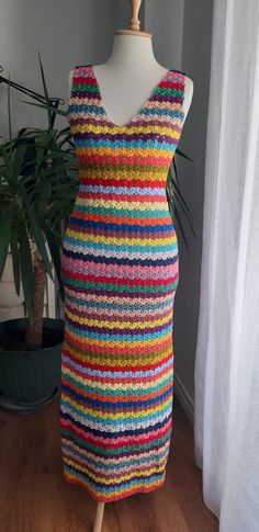 a woman's dress made out of multicolored yarn on a mannequin