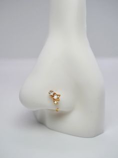 a white mannequin with a gold ring on it's head and an earring in the shape of a star