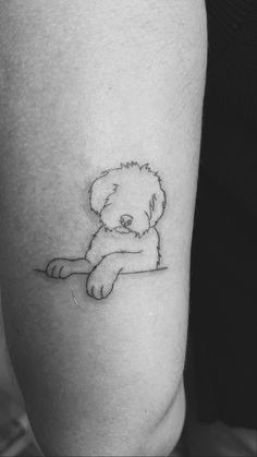 a black and white photo of a small teddy bear tattoo on the left calf leg