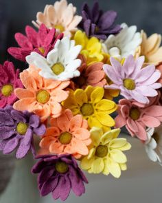 a vase filled with lots of different colored flowers