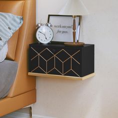 a nightstand with an alarm clock on it next to a chair