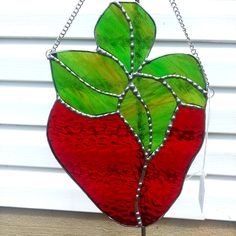 a stained glass strawberry hanging on a chain