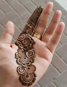 a person holding their hand with henna on it