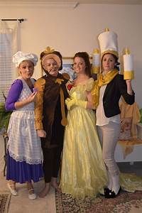 three women dressed up as princesses posing for the camera with one holding a candle in her hand