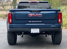 the rear end of a blue gmc sierra truck