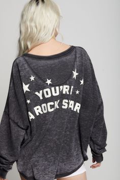 Show everyone what you are made of in style! This unique one size sweatshirt features a "Made Of Stars" disco ball graphic on the front with "You're A Rock Star" verbiage on the back. Made with soft vintage washed fabric, ribbed hems, a wide crew neckline, and a rounded high-low bottom hem for a relaxed, adaptable fit across various body types. This style features a one-size-fits-all design with stylish high-low hem details. Details Style #302264 Color: Black Made Of Stars One Size Long Sleeve S Trendy Oversized Distressed Sweatshirt, Graphic Tee Long Sleeve For Concerts, Graphic Tee Long Sleeve Tops For Concert, Grunge Crew Neck Top For Music Festival, Oversized Fall Sweatshirt With Star Print, Relaxed Fit Sweatshirt With Star Print For Fall, Acid Wash Tops With Letter Print For Loungewear, Relaxed Fit Star Print Sweatshirt For Fall, Oversized Distressed Tops For Loungewear