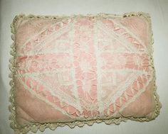 a pink and white pillow with lace on it