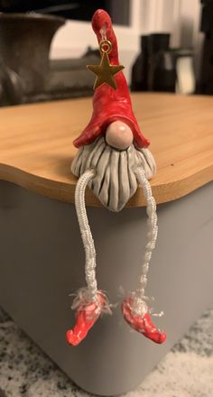 a red and white gnome figurine sitting on top of a counter