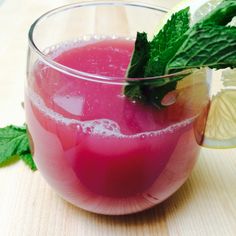 a drink in a glass with ice and mint garnish