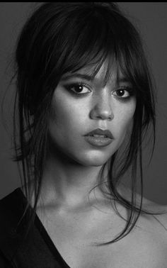 a black and white photo of a woman with long hair wearing a strapless top