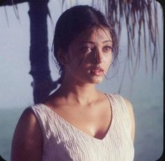 a woman standing in front of a palm tree