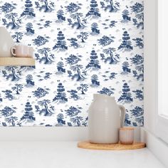 blue and white wallpaper in a kitchen with two vases on the counter top