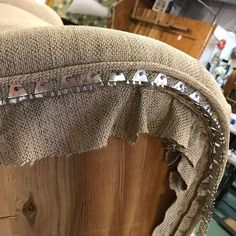 an upholstered chair with metal rivets on it