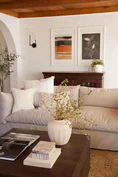 a living room with couches, tables and pictures on the wall above them is shown