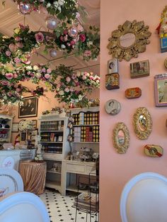 there are many plates on the wall in this room with flowers hanging from the ceiling