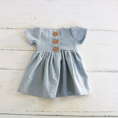 2-3 WEEK TURNAROUND TIME. This light blue, chambray cotton/linen handmade dress is the perfect addition to any little's wardrobe! Though great for all year cuteness! Perfect fall and winter with elbow length sleeves. Or summertime fun with the tank version. Dress is a elbow-sleeved or sleeveless, with a lined, slightly curved front bodice. Three wooden button closures in the back of the dress of the 3/4 sleeved version. Tank version has a V-back and 1 button. This fabric is a linen cotton blend, Cotton Day Dress With Button Back, Cotton Daywear Dress With Button Back, Blue Cotton Denim Dress With Buttons, Sleeveless Cotton Dress With Button Back, Cute Blue Dresses With Button Closure, Cute Blue Dress With Button Closure, Cotton Dresses With Button Closure For Daywear, Light Blue Short Sleeve Cotton Denim Dress, Light Blue Cotton Denim Dress With Short Sleeves