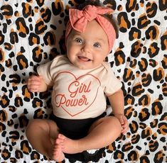 a baby girl wearing a shirt that says girl power with a heart in the middle