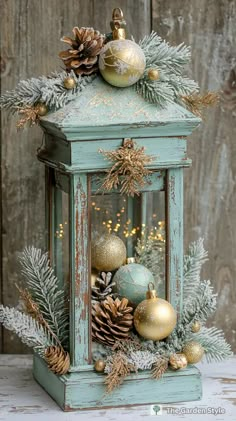 an old blue lantern with pine cones and ornaments