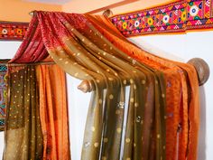 an assortment of scarves hanging on a wall