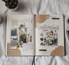 an open planner book sitting on top of a bed next to a potted plant