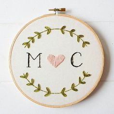 a cross stitch hoop with the word mom written in it and a heart on top