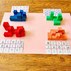 three different colored blocks on top of a piece of pink paper with numbers and times