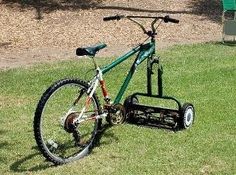 a bicycle is parked in the grass with a snow plow attached to it