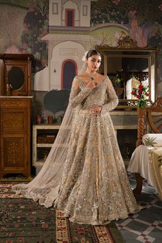 Traditional Ivory Pakistani Bridal Dress Heavily Embellished Pishwas Gown is an intricate pattern of gorgeous zardozi and fine resham craftsmanship. An ivory tulle dupatta with fully worked borders in a trailing brocade lehenga with rich borders completes this grand and majestic bridal look. Detailed Description: SKU: BB304 Detailing: Embroidery, Motifs, Naqshi, Sequins, Dabka Color: Champagne and Ivory Fabric: Jamawar, Tissue, Crimson Chiffon Design: Fully Embellished Dress with Embroidery Event: Bridal wear, Wedding Nomi Ansari, Brocade Lehenga, Pakistani Bridal Dress, Wedding Outfits For Women, Net Blouse, Gown Inspiration, Pakistani Bridal Dresses, Pakistani Bridal Wear, Gold Number