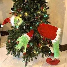 a christmas tree decorated with elf hats and lights