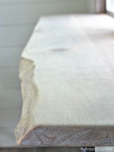 a close up view of a wooden table with white paint on it and wood grains