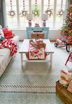 a living room decorated for christmas with presents on the coffee table and other holiday decorations