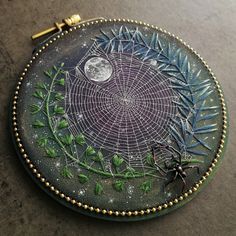 a spider sits on the ground in front of a glass plate with an intricate design