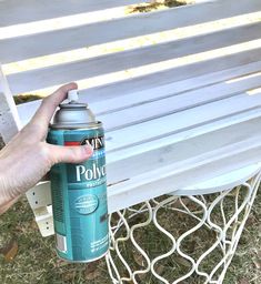 a person holding a spray paint can near a bench