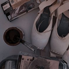 several pairs of ballet shoes sitting on top of a table next to magazines and other items