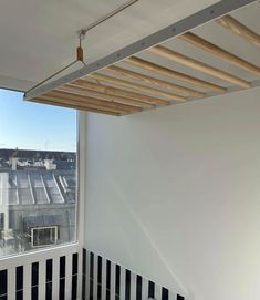 an empty room with black and white stripes on the floor, and a window overlooking rooftops